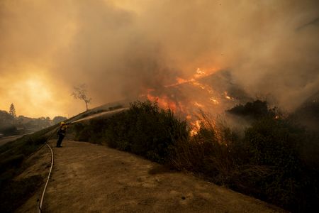 Wind-whipped Southern California wildfires prompt mass evacuations, injure 2 firefighters