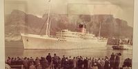 My parents Cyril and Betty Jackman, sister Pat and late brother Phillip came to South Africa in 1952 aboard Edinburgh Castle, here in a photograph on a wall of the Mount Nelson. The reflection hints at other framed photographs on the wall opposite. (Photo: Tony Jackman)<br>