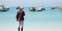 A crew member overlooking traditional ‘chukkie’ vessels moored in the Struisbaai harbour. (Photo: @ABALOBI)