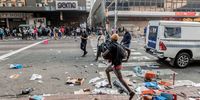 A looter in West Street, Durban, just metres from a small team of police, who are outnumbered during the July 2021 riots. (Photo: Samora Chapman)