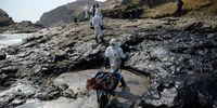 Workers clean an oil spill on Cavero beach in Callao, Peru, on Wednesday, Jan. 19, 2022. High ocean waves stemming from a massive volcanic eruption near Tonga caused an oil spill off the coast of Peru, closing beaches and halting fishing after the country's Navy failed to issue a tsunami warning. Photographer: Miguel Yovera/Bloomberg via Getty Images