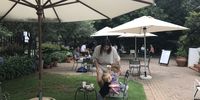 People sitting in the pretty garden select what they want from the shop up the steps. (Photo: Marie-Lais Emond) 