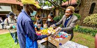 Christopher Chisanga and Esther Karimu (at the bottom of the table) serving lunch on a regular Sunday at st Francis, Parkview, Johannesburg.<br>(Photo: Angus Begg)