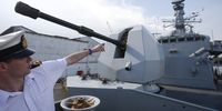 A Royal Navy officer points towards the main gun of the frigate HMS Sutherland moored at Sembawang Wharf in 2018 (Photo: EPA-EFE / Wallace Woon)