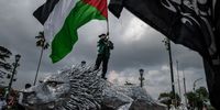 YOGYAKARTA, INDONESIA - MAY 21: An Indonesian muslim carries a Palestinian flag as they gather in the streets during a rally in support of Palestine on May 21, 2021 in Yogyakarta, Indonesia. Indonesian Muslims staged a rally in support of a ceasefire that was announced overnight after 11 days of fighting between the two sides claimed over 200 lives in Palestinian territory and over 10 lives in Israeli towns. (Photo by Ulet Ifansasti/Getty Images)