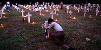 epaselect epa10950222 A Filipino boy scout lights a candle on the grave of his comrade at the National Heroes Cemetery on the eve of All Saints Day in Taguig city, Metro Manila, Philippines, 31 October 2023. Millions of Filipinos will flock to cemeteries around the country to visit departed relatives and loved ones to mark All Saints Day and All Souls Day on 0?1 and 02 November.  EPA-EFE/FRANCIS R. MALASIG