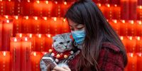 epaselect epa10422474 A woman carrying a cat walks on the first day of the Chinese Lunar New Year in the Jade Buddha Temple, in Shanghai, China, 22 January 2023. Chinese New Year, also known as the Spring Festival, begins today, 22 January 2023. According to the Chinese zodiac, this year represents the year of the Water Rabbit. Traditionally, on the first day of the Lunar New Year, people head to the temple to light their incense sticks, hang prayers and coins on a wishing and money tree, pray for blessings and good luck in the year ahead.  EPA-EFE/ALEX PLAVEVSKI