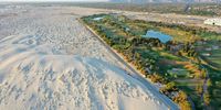 PALM DESERT, CALIFORNIA - JULY 13: An aerial view of a golf course next to undeveloped desert on July 13, 2022 in Palm Desert, California. According to the U.S. Drought Monitor, more than 97 percent of the state of California's land area is in at least severe drought status, with nearly 60 percent in at least extreme drought. California is now in a third consecutive year of drought amid a climate change-fueled megadrought in the Southwestern United States. (Photo by Mario Tama/Getty Images)