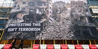 Police officers look at a large protest banner, installed on scaffolding opposite the headquarters of the Labour Party, on July 22, 2025 in London, England. Activists from the group 'Led By Donkeys' have installed the huge banner showing a photograph of destruction in Gaza's Jabaliya camp directly across from the Labour Party's headquarters, in protest of what they say is the government's complicity in genocide. The slogan reads "Protesting this isn't terrorism," referring to the government's recent proscription of the pro-Palestinian group, Palestine Action, after four of the group's members broke into RAF Brize Norton and spray-painted two Voyager aircraft on June 20. (Photo by Leon Neal/Getty Images)