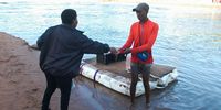 Zama Chamane pays Thandokuhle Msomi his R5 fare for helping her cross the uMlazi River. (Photo: Phumlani Thabethe)