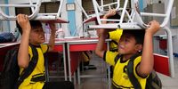 School students lift chairs as they take cover during a disaster simulation at Anyelir 1 elementary school in Depok, Indonesia, 20 July 2023. The National Disaster Management Agency noted that there were 988 natural disasters that hit Indonesia from January to May  2023, 11 of which were earthquakes, and dozens of fires and floods in various cities in Indonesia.  EPA-EFE/ADI WEDA