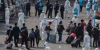 Chinese workers and health officials wear protective white suits as travellers from Wuhan gather to take buses as they are processed and taken to do 14 days of quarantine, after arriving on the first trains to Beijing on April 8, 2020 in Beijing, China. China lifted its lockdown on Wuhan, the first epicentre of COVID-19 after 76 days, allowing healthy people to leave. China recorded for the first time since January 21st no coronavirus-related deaths. With the pandemic hitting hard across the world, officially the number of coronavirus cases in China is dwindling, ever since the government imposed sweeping measures to keep the disease from spreading.  For more than two months, millions of people across China have been restricted in how they move from their homes, while other cities have been locked down in ways that appeared severe at the time but are now being replicated in other countries trying to contain the virus. Officials believe the worst appears to be over in China, though there are concerns of another wave of infections as the government attempts to reboot the worlds second largest economy. In Beijing, it is mandatory to wear masks outdoors, some retail stores still operate on reduced hours, restaurants employ social distancing among patrons, and tourist attractions at risk of drawing large crowds remain closed or allow only limited access.  Monitoring and enforcement of virus-related measures and the quarantine of anyone arriving to Beijing is carried out by neighborhood committees and a network of Communist Party volunteers who wear red arm bands. Since January, China has recorded more than 81,000 cases of COVID-19 and at least 3200 deaths, mostly in and around the city of Wuhan, in central Hubei province, where the outbreak first started. (Photo by Kevin Frayer/Getty Images)