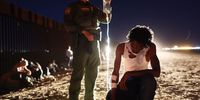 YUMA, ARIZONA - MAY 18: A U.S. Border Patrol agent holds an IV bag for an immigrant from Jamaica as agents treat him for dehydration after crossing the border from Mexico on May 18, 2022 in Yuma, Arizona. Title 42, the controversial pandemic-era border policy enacted by President Trump, which cites COVID-19 as the reason to rapidly expel asylum seekers at the U.S. border, is set to officially expire on May 23rd. A federal judge in Louisiana is expected to deliver a ruling this week on whether the Biden administration can lift Title 42. (Photo by Mario Tama/Getty Images)