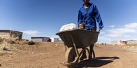 Anna Le Roux, 38, makes her way home after collecting water from a communal tap in Ratanang, Klerksdorp. Unemployed Le Roux sometimes makes money by charging her neighbours for water deliveries.<br>Photo: Shiraaz Mohamed.