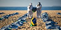 RIO DE JANEIRO, BRAZIL - APRIL 30: Activists from NGO Rio de Paz carry a Brazilian flag as they display hundreds of plastic bags, representing dead bodies during an event to pay homage to the  400,000 dead of coronavirus and protest against official response to pandemic at Copacabana Beach on April 30, 2021 in Rio de Janeiro, Brazil. The death toll in Brazil passed 400,000 people on Thursday 29, as the country struggles to get vaccines and administrate them. Brazilian President Jair Bolsonaro, who initially downplayed the virus, undergoes a Congress probe about mismanagement of the pandemic and sees his support plummet. (Photo by Buda Mendes/Getty Images)