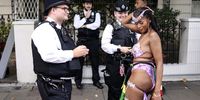A dancer performs in front of police officers during the Notting Hill Carnival in London, Britain, 28 August 2023. Notting Hill is the largest street carnival in Europe and a community-led celebration of Caribbean history and culture, this year running from 27 to 28 August.  EPA-EFE/NEIL HALL