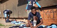 Soccer player Kopanyo Hlakodi (20) straps up his soocer boots in preparation for his match ahead. Hlakodi plays for Mswenko FC and resides in Naledi. He has been playing for 7 years and says he enjoys every minute he is out on the field. (Photo: Kabelo Mokoena)