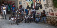epa09329422 A group of journalists work next to a mural of the assassinated president Jovenel Moise, in Port-au-Prince, Haiti, 07 July 2021. The President of Haiti Jovenel Moise, was assassinated on 07 July by armed men who carried out an attack on his residence in the early morning in the Pelerin neighborhood of Port-au-Prince, said interim prime minister, Claude Joseph.  EPA-EFE/JEAN MARC HERVE ABELARD
