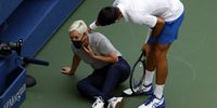 Novak Djokovic tries to help a linesperson after hitting her with a ball in the throat. (Photo: EPA-EFE / Jason Szenes)