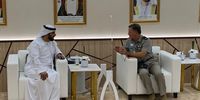 Air Marshal Sampson (right) sits in front of a portrait of Sheikh Mohammed at an arms fair. (Photo: MOD)
