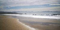 Robberg Beach with The Beacon Isle in the distance framed by The Crags.