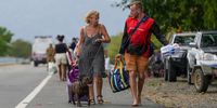 Residents evacuate with their belongings after being rescued by boat at Machan Beach in Cairns, Queensland, Australia, 18 December 2023. Residents in far north Queensland are bracing for more rain and further significant flooding.  EPA-EFE/NUNO AVENDANO AUSTRALIA AND NEW ZEALAND OUT