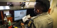 An immigration officer processes the entry of a traveler entering South Africa at passport control.<br>Photo / Shiraaz Mohamed.