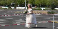 DUSSELDORF, GERMANY - MAY 05: Janine Scholz, dressed in a cream white dress runs across the empty car park prior to her marrigare to Philip Scholz during the first ever wedding ceremony at the Autokino Dusseldorf drive-in cinema during the novel coronavirus crisis on May 5, 2020 in Dusseldorf, Germany. A total of three couples are marrying at the drive-in today with guests allowed to attend in their cars. Drive-in cinemas have become a popular alternative venue for events ranging from weddings, theatre performances, musicals and movies as lockdown measures keep traditional venues off limits. (Photo by Andreas Rentz/Getty Images)