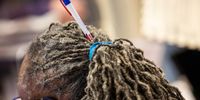 An election official wears a pen in their hair at an early voting polling location for the 2020 Presidential election at Madison Square Garden in New York, U.S., on Monday, Oct. 26, 2020. With eight days until the election, 59.4 million people have cast ballots in-person at early voting centers or by mail, according to the U.S. Elections Project. Photographer: Jeenah Moon/Bloomberg via Getty Images