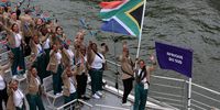 PARIS, FRANCE - JULY 26: Caitlin Rooskrantz and Akani Simbine, Flagbearers of Team South Africa, wave their flag on the team boat during the opening ceremony of the Olympic Games Paris 2024 on July 26, 2024 in Paris, France. (Photo by Lars Baron/Getty Images)