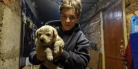 epaselect epa10423765 Evelina poses with her puppy Umka in the basement of her apartment block, where she lives with her mother, grandmother, and four neighbors in the town of Lyman, Donetsk region, Ukraine, 22 January 2023. Lyman was re-captured by Ukraine's armed forces in October. Before the beginning of active combat action population of Lyman was around 41,000. After being under Russian occupation, without electricity, water and gas supply, infrastructure is slowly renewing. Russian troops entered Ukraine terriroty on 24 February 2022, starting an armed conflict that has provoked destruction and a humanitarian crisis.  EPA-EFE/OLEG PETRASYUK