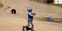 A young child runs home after receiving a meal from Lulama Maseti’s pop-up soup kitchen in Makhanda. (Photo: Black Star / Spotlight)