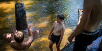 KNUTSFORD, UNITED KINGDOM - AUGUST 10: Youths cool off in the Peover Eye, a small river that meanders through the Cheshire countryside, on August 10, 2022 in Knutsford, United Kingdom. The Met Office, the UK's weather service, issued an amber extreme heat warning for southern and central England and parts of Wales from midnight on Thursday until Sunday. Temperatures are expected to reach up to 35C in some parts of the country. (Photo by Christopher Furlong/Getty Images)
