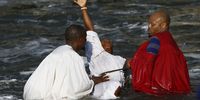 A Morian Africa Church member reaching to the sky after being baptised. People came out of the water visibly emotional and touched by the experience.  Photo: Felix Dlangamandla