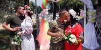 DRUZHKIVKA, UKRAINE - JUNE 12: Soldiers Vitalii Orlich and his bride Kristina (L) and Volodymyr Mykhailuk and his bride Hrystyna  kiss after being married during joint wedding ceremony on June 12, 2022 in Druzhkivka, Donetsk Oblast, Ukraine. All four are soldiers in the Ukrainian army serving with the 14th separate mechanized brigade in eastern Ukraine. Both couples met while serving in the army after the start of the war with Russia.  Ukrainian forces are engaged in a back-and-forth battle with Russia for key towns along the western edge of the Donetsk and Luhansk regions, where Moscow is focusing its firepower. (Photo by Scott Olson/Getty Images)