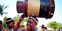 Women dancers from a tshigombela dance group carry a cowhide drum in preparation for a performance. (Photo: Lucas Ledwaba / Mukurukuru Media)
