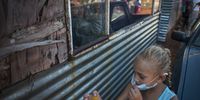 An image taken on 7 May 2020, shows  girl passing food through the window after collecting food in Pango Camp. The camp is home to a number of white families who are in need of food and other necessities. According to residents of Pango Camp, The South African government has not provided food parcels for white residents of the camp but has supplied residents of black occupied informal settlements. The residents rely on food handouts from private donors. (Photo: Shiraaz Mohamed)