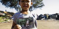 A girl shows off a picture she found while rummaging through garbage from Stellenbosch suburbs. (Photo: Daniel Steyn)