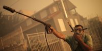 A local resident wearing a scuba-diving mask sprays water at the entrance of a house during a wildfire at Lagonisi area in Attica, Greece, 17 July 2023. Firefighting forces are battling a blaze that broke out in the Kouvaras area in Attica, while a warning was sent via the emergency number 112 to evacuate several settlements in southeast Attica. A force of 55 firefighters and 20 fire engines, two units on foot and 31 Romanian firefighters with five water tankers have been deployed to put out the fire, assisted by six fire-fighting aircraft and four helicopters from the air. EPA-EFE/KOSTAS TSIRONIS