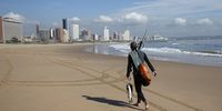 A spear fisherman walks along Ushaka Beach with his catch in Durban. Beaches are closed in an effort to curb coronavirus infections. (Photo: Rogan Ward)