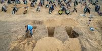 IRPIN, UKRAINE - APRIL 21: In this drone image, A grave digger prepares the ground for a funeral at a cemetery on April 21, 2022 in Irpin, Ukraine. The first several rows contain people killed during the Russian occupation of the area. At least 700 murdered civilians have been found in towns around Kiev, according to Ukrainian authorities. The slayings launched investigations for possible war crimes perpetuated by Russian forces during the occupation. (Photo by John Moore/Getty Images)