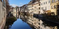 Old houses are reflected in the water. Photographer: Ben Ebenho