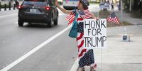 CLEARWATER, FL - OCTOBER 25: Angela Harrison, a supporter of President Donald Trump, waves at cars passing by near the Pinellas County Courthouse early voting polling station on October 25, 2020 in Clearwater, Florida. The Pinellas County Sheriff's Office stated they would station deputies outside five polling locations after armed security guards were seen at a polling site last week. (Photo by Octavio Jones/Getty Images)