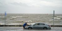 BILOXI, MS - AUGUST 30: A man helps a stranded motorist in floodwaters on Beach Blvd. on August 30, 2021 in Biloxi, Mississippi. Tropical Storm Ida made landfall as a Category 4 hurricane yesterday in Louisiana and brought flooding and wind damage along the Gulf Coast. (Photo by Sean Rayford/Getty Images)