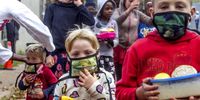 The distribution of masks to children waiting in line at the soup kitchen was as important as a meal. Morgan Du Toit (front, right), Jenny Knoetze (front, left), Monique Knoetze and Vicky Oliphant (back, left), and Gugulethu Ncube (holding lunch box)  receive masks and soup at Victoria Yards, Johannesburg.<br>(Photo: Lungile Hlatshwayo)