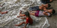 epa09957462 Children refresh themselves in sea water on a hot afternoon near the Arabian Sea coast in Mumbai, India, 19 May 2022. According to the India Meteorological Department (IMD), temperatures in Delhi and the National Capital Region are expected to exceed 43 degrees Celsius amid a heat wave sweeping through the country.  EPA-EFE/DIVYAKANT SOLANKI