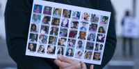 A woman holds a card with images of alleged victims of gender based violence. (Photo: EPA-EFE/NIC BOTHMA)