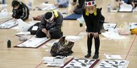 epa09667092 An elementary school student looks at her work during the New Year's first calligraphy contest at Nippon Budokan in Tokyo, Japan, 05 January 2022. About 1,270 people of all ages from across the nation participated in the annual event to display their Japanese calligraphic skills.  EPA-EFE/FRANCK ROBICHON