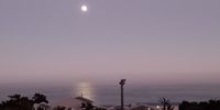 Supermoon setting over Camps Bay. Photographer: Suzanne Himeley