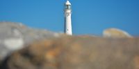Slangkop Lighthouse - The last remaining Victorian Lighthouse in South Africa - as seen from the beach. Photographer: Neville Lance